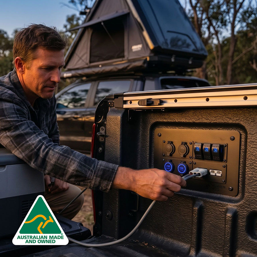 Man connecting a power cable to a portable power station outdoors.